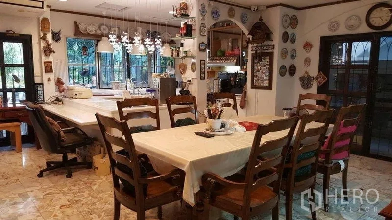 Detached House for rent in Bang Kapi, Bangkok - Open-plan dining area featuring a long wooden table and hanging lights.