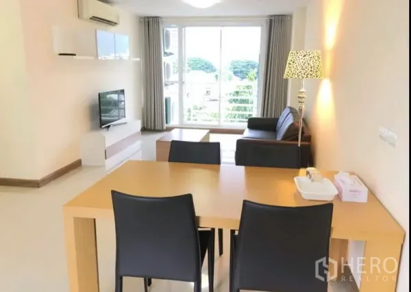 Condominium for rent in Phra Khanong, Bangkok - Bright open-plan living and dining room with wood table, four black chairs, leather sofa, TV console and floor-to-ceiling window.