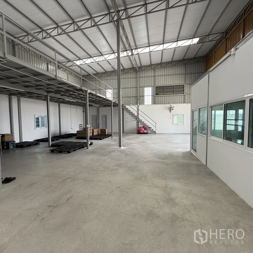 仓库 for rent or sale in Khlong Luang, Pathum Thani - 室内开阔空间，带夹层、楼梯与办公室分区。