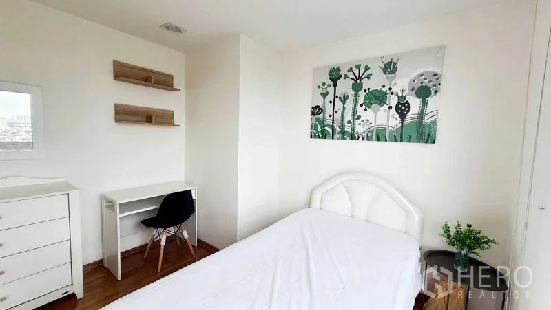 Condominium for sale in Bang Kho Laem, Bangkok - Cozy single bedroom with desk, wall shelves and white furniture.