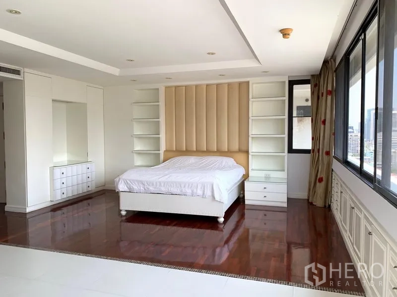 公寓 出售在Khlong Toei, Bangkok - 主卧宽敞，软包床头、白色柜体与城市景观