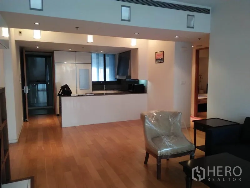 Condominium for rent in Sathon, Bangkok - Open-plan living area with wood flooring and modern kitchen island in a Sathon condo.