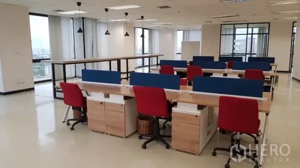 办公空间 出租在Din Daeng, Bangkok - 开放式工位区，长条办公桌、红色座椅与吊灯，环景窗旁。