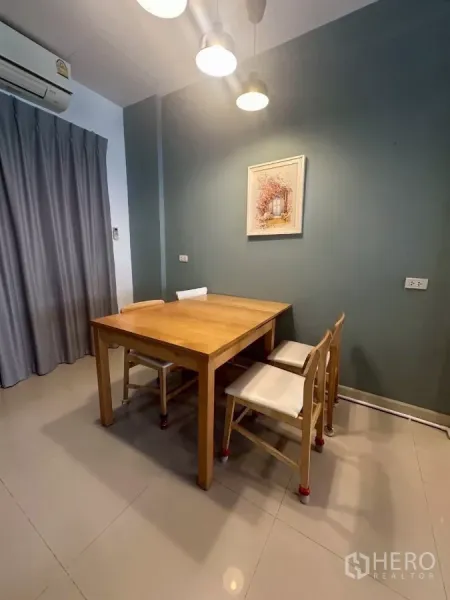 Townhouse for rent in Chom Thong, Bangkok - Dining corner with wooden table, four chairs and pendant lights.