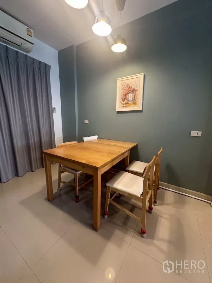 Townhouse for rent in Chom Thong, Bangkok - Dining corner with wooden table, four chairs and pendant lights.