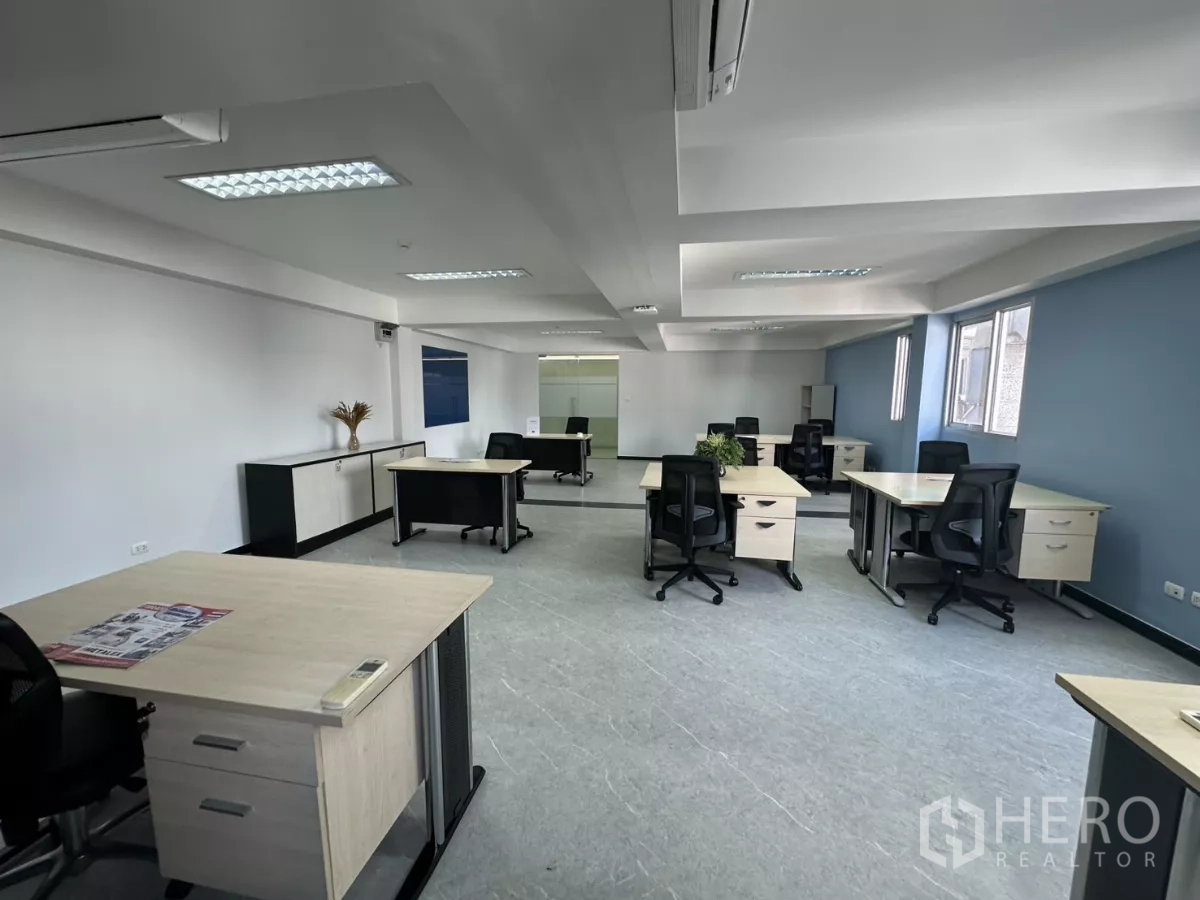 Office Space for rent in Watthana, Bangkok - Spacious furnished workspace with a row of windows, AC units and ergonomic chairs.