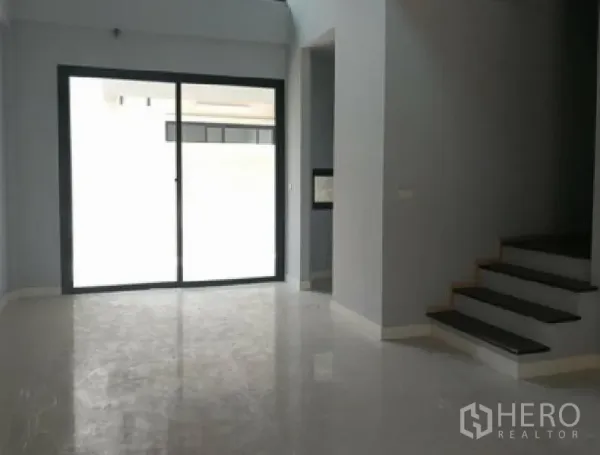 ทาวน์เฮาส์ ให้เช่าในYan Nawa, Bangkok - พื้นที่นั่งเล่นแบบโอเพ่นสเปซ พื้นมันเงา ประตูกระจกบานเลื่อนไปยังระเบียง และบันไดด้านข้าง