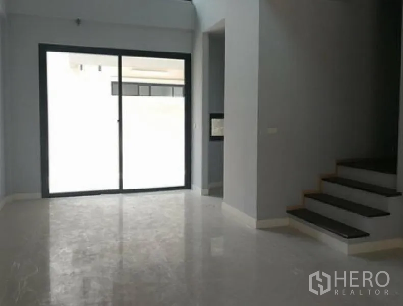 ทาวน์เฮาส์ ให้เช่าในYan Nawa, Bangkok - พื้นที่นั่งเล่นแบบโอเพ่นสเปซ พื้นมันเงา ประตูกระจกบานเลื่อนไปยังระเบียง และบันไดด้านข้าง