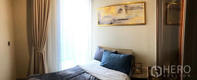 Condominium for rent in Watthana, Bangkok - Second bedroom with soft drapes, wall art and built-in wardrobe.