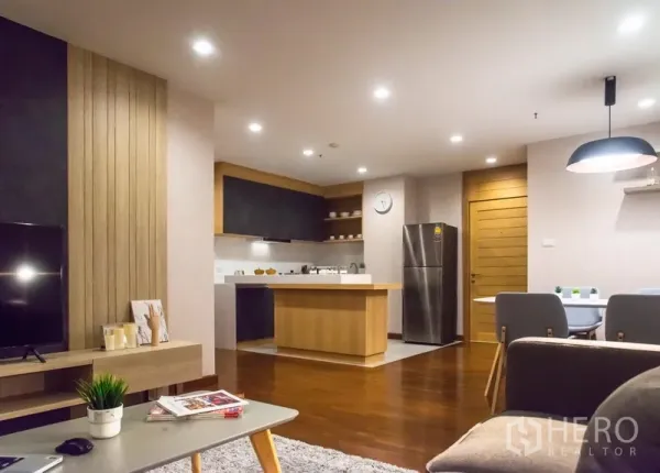 Condominium for rent in Pathum Wan, Bangkok - Open-plan living area with wood floors and a modern kitchen island in a Bangkok condo.