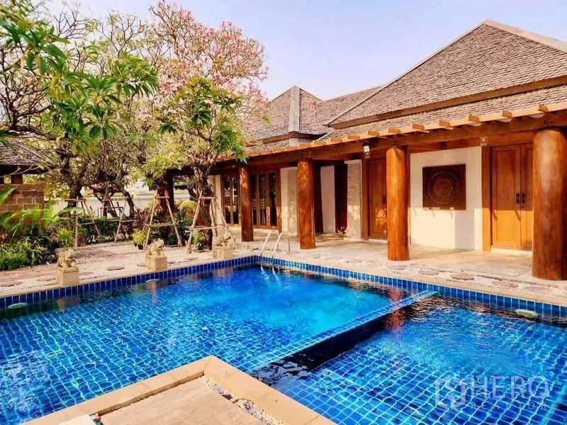 Detached House for sale in Bueng Kum, Bangkok - Blue-tiled swimming pool in a tropical garden courtyard with timber columns.