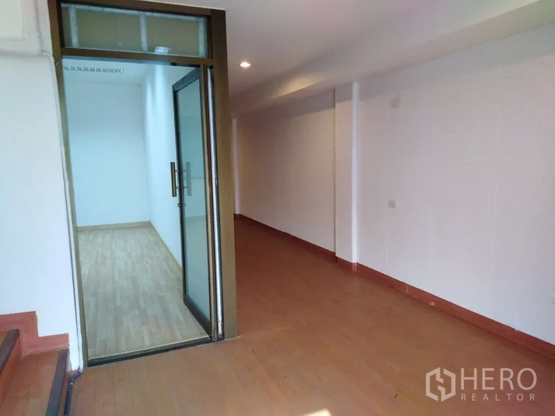 Office Space for sale in Bang Kapi, Bangkok - Entry hall with a glass door leading to a small office room and a long corridor.