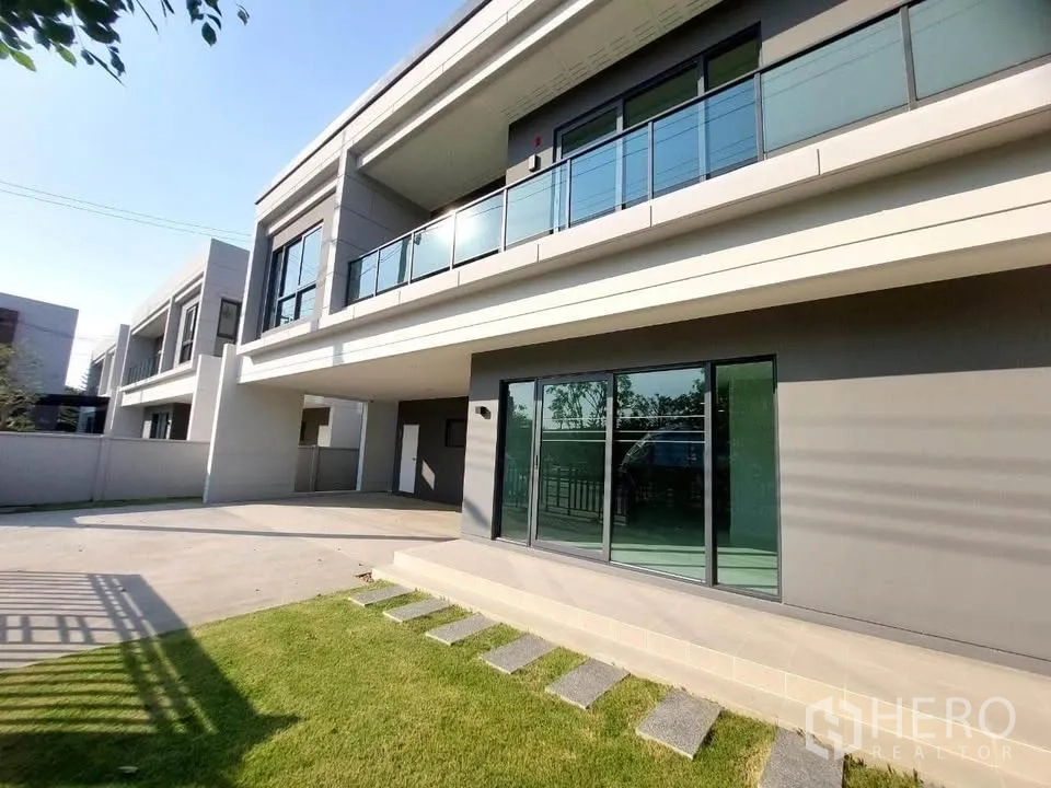บ้านเดี่ยว for rent or sale in Bang Phli, Samut Prakan - สนามหญ้าและเฉลียงข้างบ้าน ประตูกระจกบานเลื่อนและระเบียงกระจกด้านบน