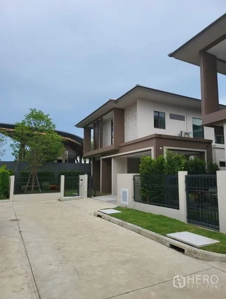 Detached House for rent in Bang Kapi, Bangkok - Modern two-storey detached house exterior with gated driveway and landscaped yard.