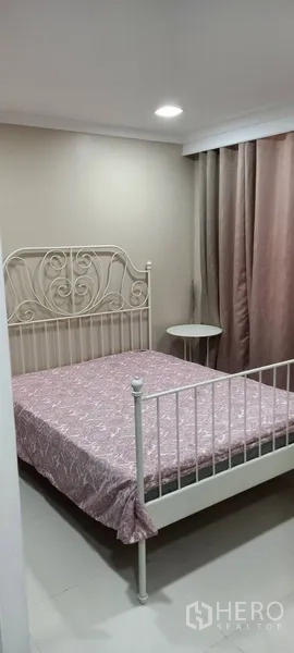 公寓 出租在Watthana, Bangkok - 温馨卧室，白色金属床架与落地窗帘。