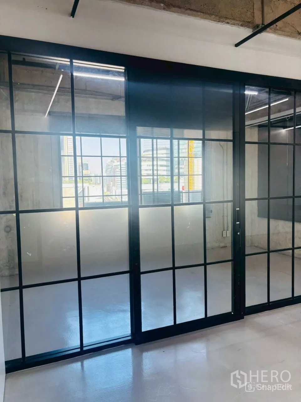 สำนักงาน ให้เช่าในKhlong Toei, Bangkok - มุมใกล้ของฉากกั้นกระจกบานเลื่อนกรอบดำ สะท้อนเส้นขอบฟ้าเมือง