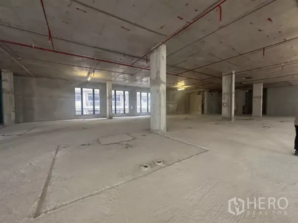 零售空间 出租在Watthana, Bangkok - 毛坯商用空间，外露消防喷淋、承重柱与多扇窗。