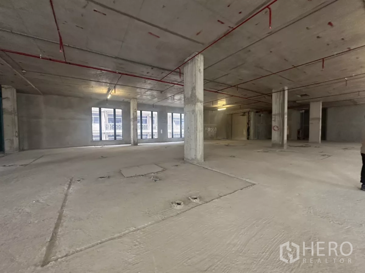 零售空间 出租在Watthana, Bangkok - 毛坯商用空间，外露消防喷淋、承重柱与多扇窗。