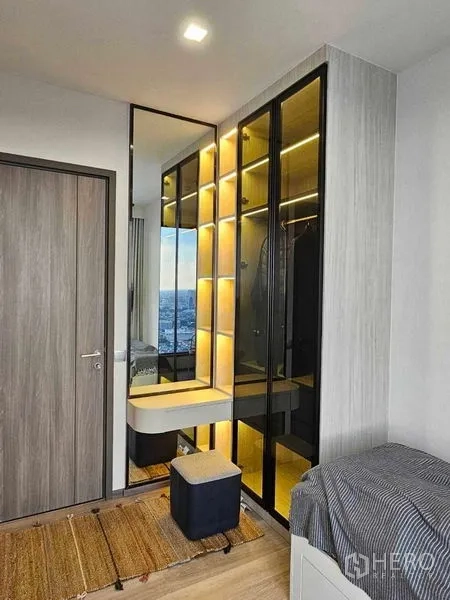 คอนโด ให้เช่าในBang Kho Laem, Bangkok - มุมห้องนอนแขกพร้อมตู้เสื้อผ้าบานกระจกมีไฟและโต๊ะเครื่องแป้งขนาดกะทัดรัด