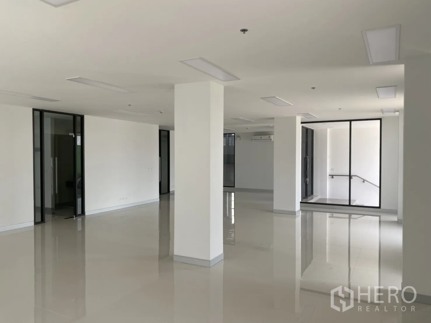 Warehouse for rent in Chachoengsao - Bright open‑plan office interior with white walls, glass partitions and tiled floors.