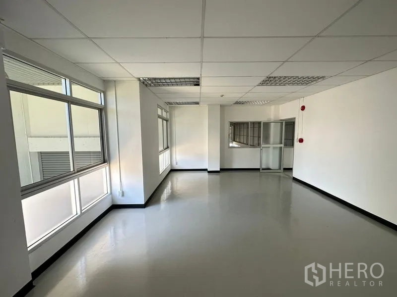 Factory for rent in Bang Bo, Samut Prakan - Bright office space with large windows, suspended ceiling and glossy floor inside the factory.