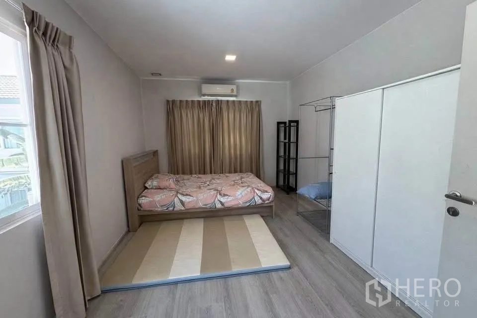 Semi-detached House for rent in Prawet, Bangkok - Bright bedroom with bed, wardrobe, large window, and air conditioner.