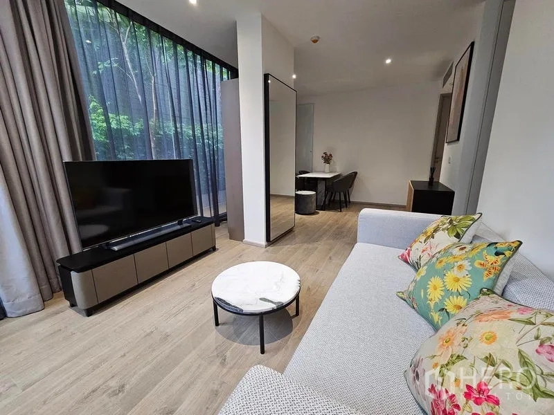 คอนโด ให้เช่าหรือขาย - ห้องนั่งเล่นสว่าง โซฟา ทีวี โต๊ะกลางหินอ่อน ผ้าม่านสูงจรดเพดาน