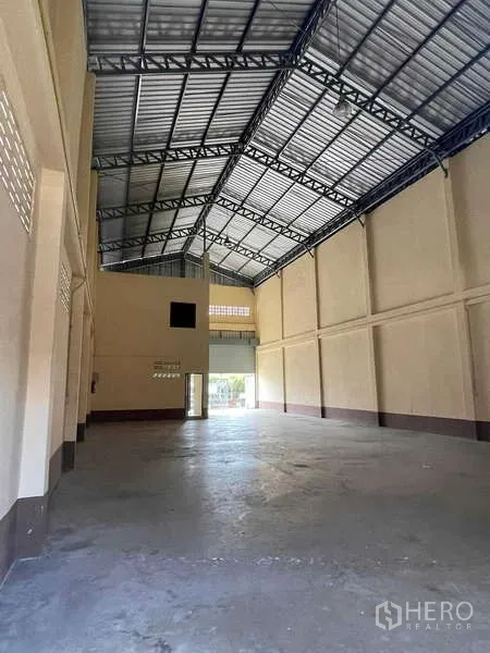 Warehouse for rent in Bang Bua Thong, Nonthaburi - Spacious warehouse hall with tall walls, skylights and wide loading door for easy truck access.