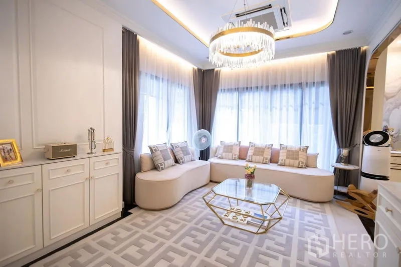 Detached House for sale in Pak Kret, Nonthaburi - Another angle of the living lounge showing corner windows and chandelier.