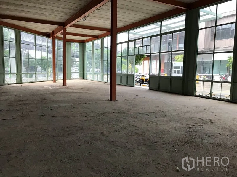 零售空间 出租在Bang Na, Bangkok - 明亮转角展示空间，双面玻璃围合与外露钢梁。