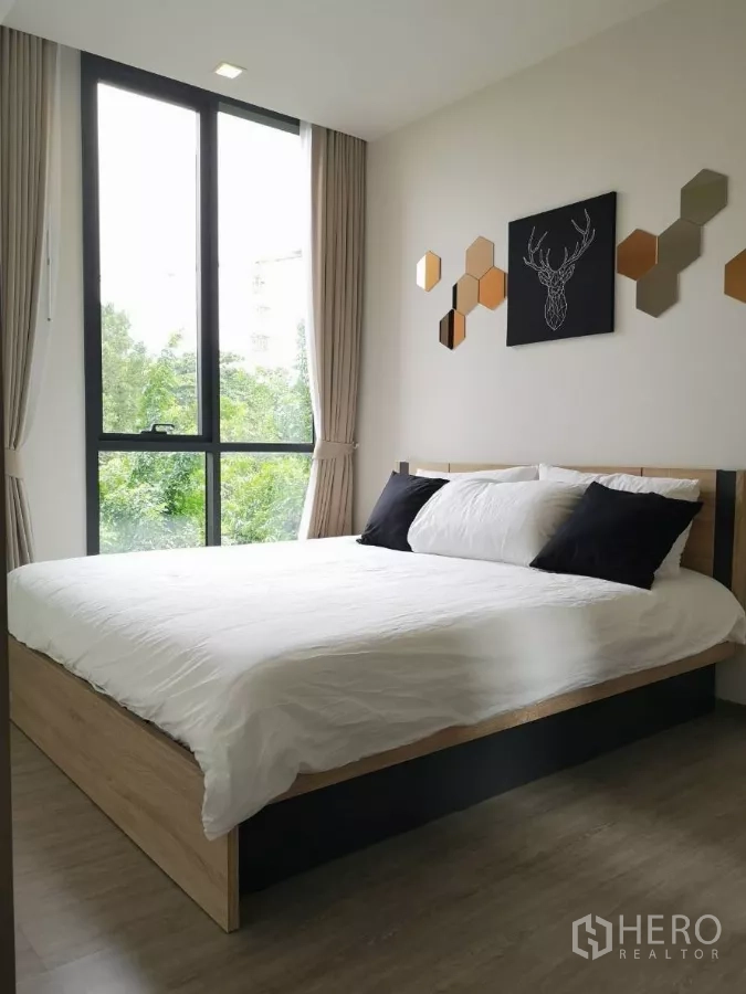 คอนโด ให้เช่าในWatthana, Bangkok - ห้องนอนสไตล์มินิมอล เตียงไม้ ผ้าปูขาว งานตกแต่งผนัง และหน้าต่างสูงจรดเพดานวิวต้นไม้