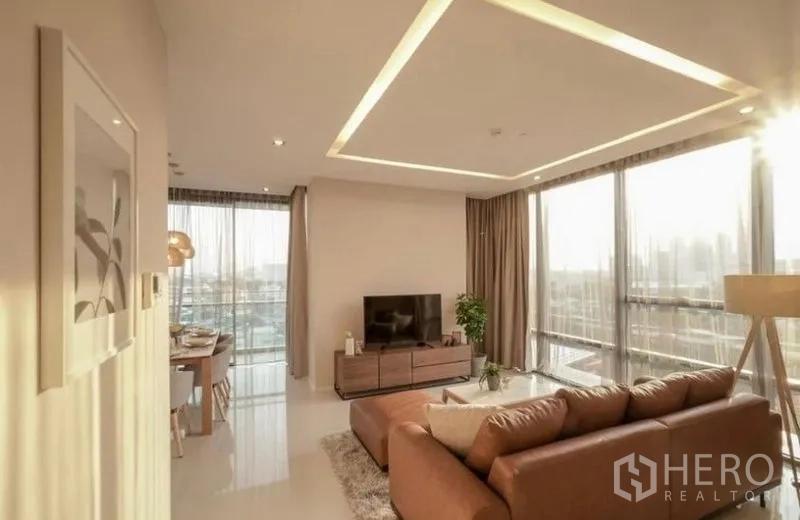 คอนโด ให้เช่าในSathon, Bangkok - ห้องนั่งเล่นฝ้าซ่อนไฟและหน้าต่างรอบด้านยามพระอาทิตย์ตก