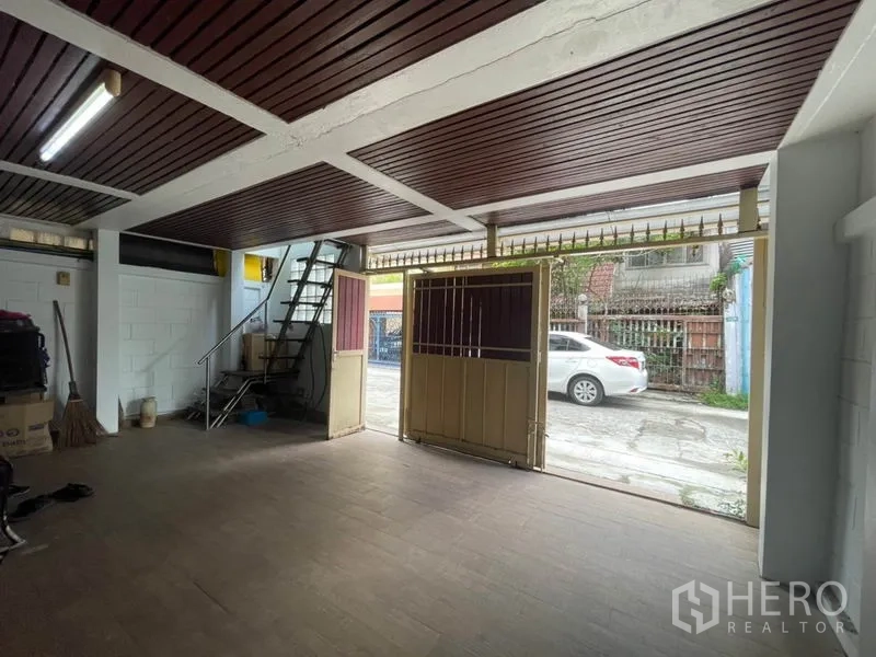 ทาวน์เฮาส์ ขายในKhlong Toei, Bangkok - ที่จอดรถในร่ม ฝ้าไม้ พื้นกระเบื้อง และประตูบานเลื่อนเปิดออกสู่ซอย