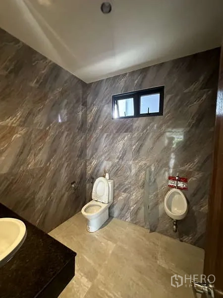 Factory for rent in Lam Luk Ka, Pathum Thani - Restroom with tiled walls, toilet, urinal and vanity.