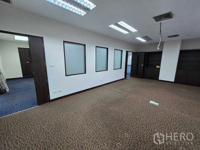 Office Space for rent in Khlong Toei, Bangkok - Carpeted meeting or manager’s room with frosted interior windows and ceiling lights.