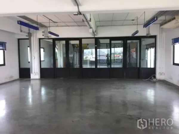 Home Office for rent or sale in Wang Thonglang, Bangkok - Spacious office area facing black-framed glass meeting rooms with multiple windows.