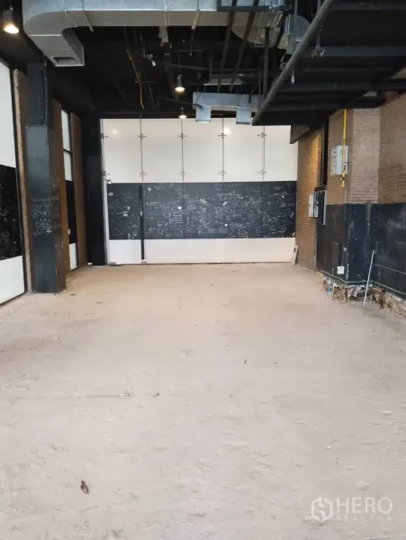 พื้นที่ขายปลีก ให้เช่าในKhlong Toei, Bangkok - พื้นที่ค้าปลีกสภาพเปล่า เพดานสูงเดินท่อดักท์ ผนังอิฐตกแต่ง และพื้นซีเมนต์ดิบ.