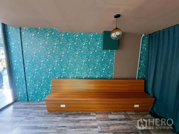 零售空间 出租在Bang Rak, Bangkok - 木质长椅座位区，绿色花纹特色墙与木纹地板。