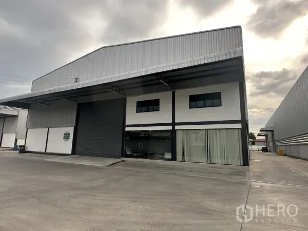 คลังสินค้า ให้เช่าในBang Phli, Samut Prakan - มุมมองด้านหน้าโกดังผนังเมทัลชีท ประตูม้วนขนาดใหญ่ สำนักงานกระจก และลานคอนกรีตกว้าง