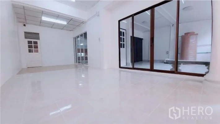 ทาวน์เฮาส์ ขาย - โถงนั่งเล่นโล่ง พื้นกระเบื้องแวววาวและผนังกระจกกั้นห้อง