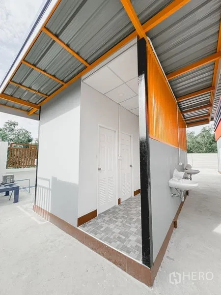 货栈 出租或出售在Khlong Luang, Pathum Thani - 室外卫生间与服务区，带洗手池、地砖和金属雨棚。