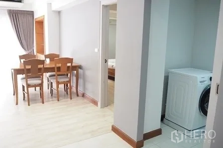 Condominium for rent in Pathum Wan, Bangkok - Hallway with dining set and a separate laundry nook with washing machine.