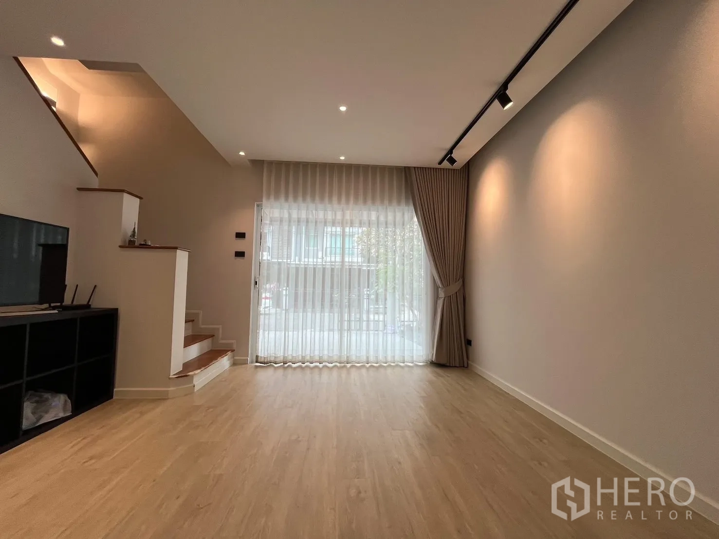 ทาวน์เฮาส์ ให้เช่าในPrawet, Bangkok - ห้องนั่งเล่นโล่ง มีบันได ไฟราง และประตูกระจกบานเลื่อนผ้าม่านโปร่ง