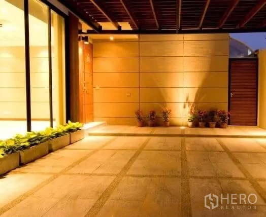 Detached House for rent in Khlong Toei, Bangkok - Covered carport and entry patio with tiled flooring and wall lights.