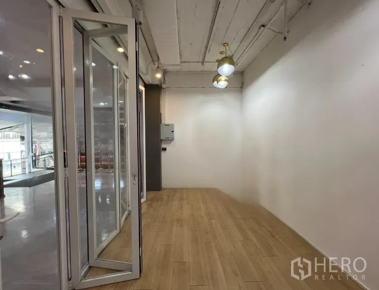 พื้นที่ขายของ for rent in Pathum Wan, Bangkok - ภายในร้านทรงลึก พื้นไม้ ผนังสีขาว โคมไฟห้อย มองเห็นโถงอาคาร
