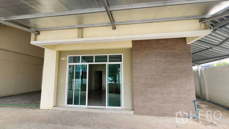 Factory for rent in Samut Sakhon - Front office facade with sliding glass doors under metal awning.