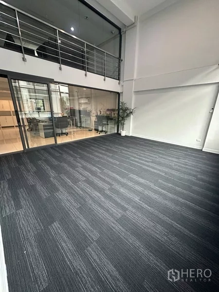 Home Office for rent - Carpeted studio space with double-height ceiling and internal glass wall.