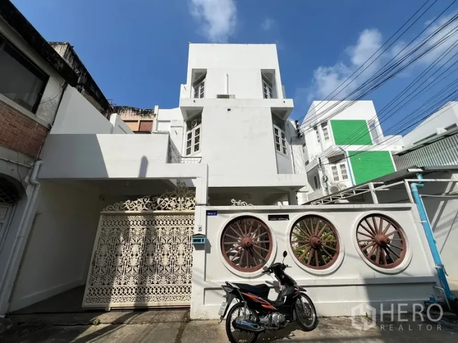 Home Office for rent in Watthana, Bangkok - Front exterior of a multi-storey white home office with an ornate gated fence.