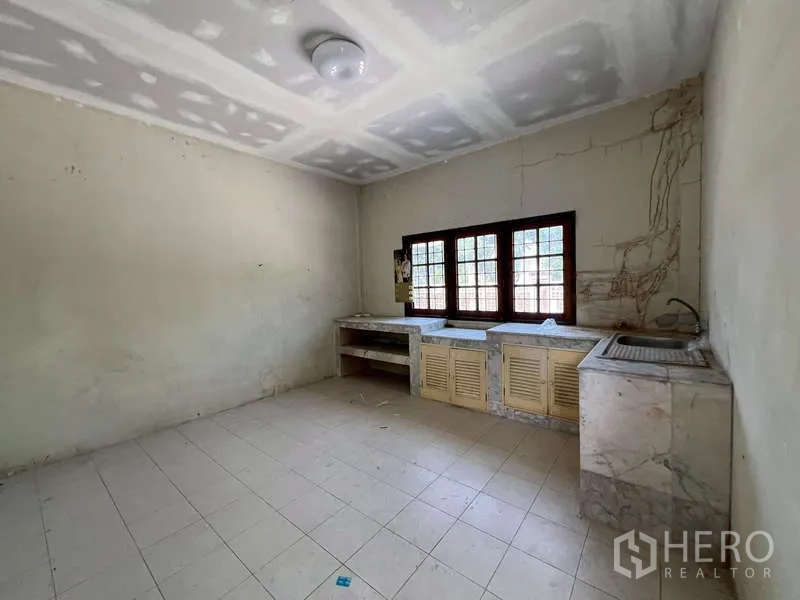 Detached House for rent in Prawet, Bangkok - Basic Thai kitchen with tiled floor, marble counters and window.