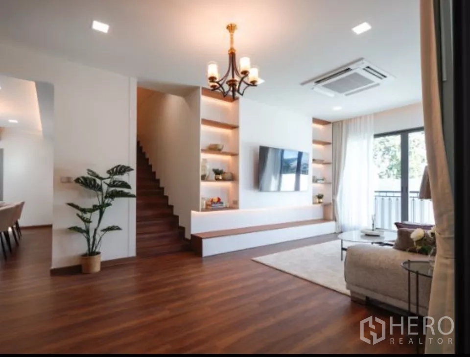 บ้าน ให้เช่าในSattahip, Chon Buri - ห้องนั่งเล่นอบอุ่น ผนังทีวีบิลต์อินพร้อมชั้นวาง พื้นไม้ และบันได